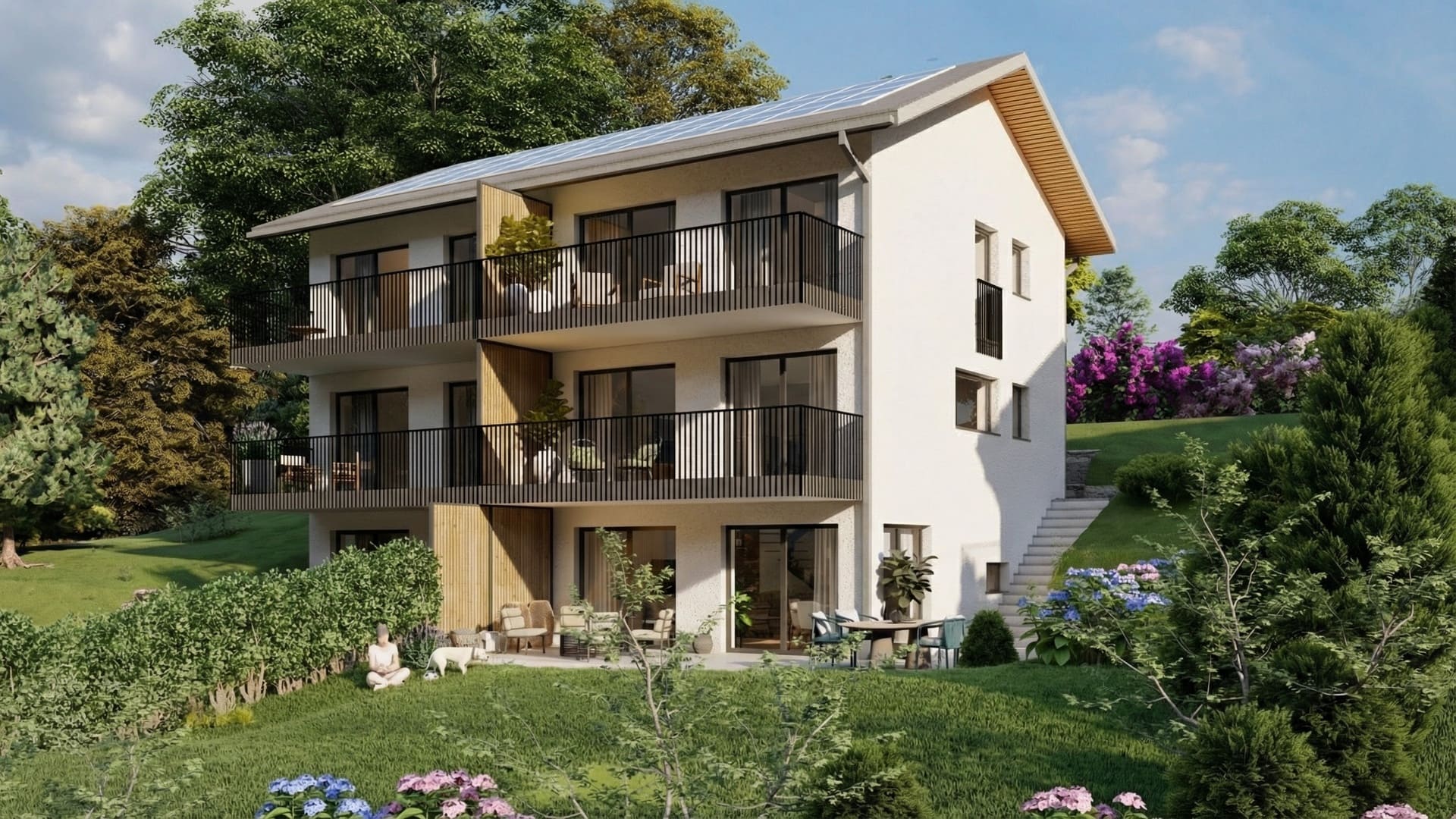 Immeuble résidentiel neuf à façade blanche avec balcons noirs, bardage bois, grandes baies vitrées et jardin paysager ensoleillé.